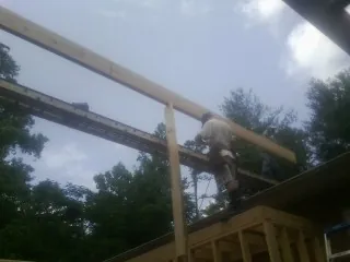 Carpenter setting a ridge beam over a new addition frame — Ice Dam Removal by Roofing Brothers in Taneytown