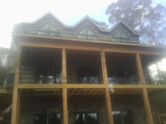 Dormers and porch framing on a large log home under construction — Roof Coating work by our crew in Taneytown