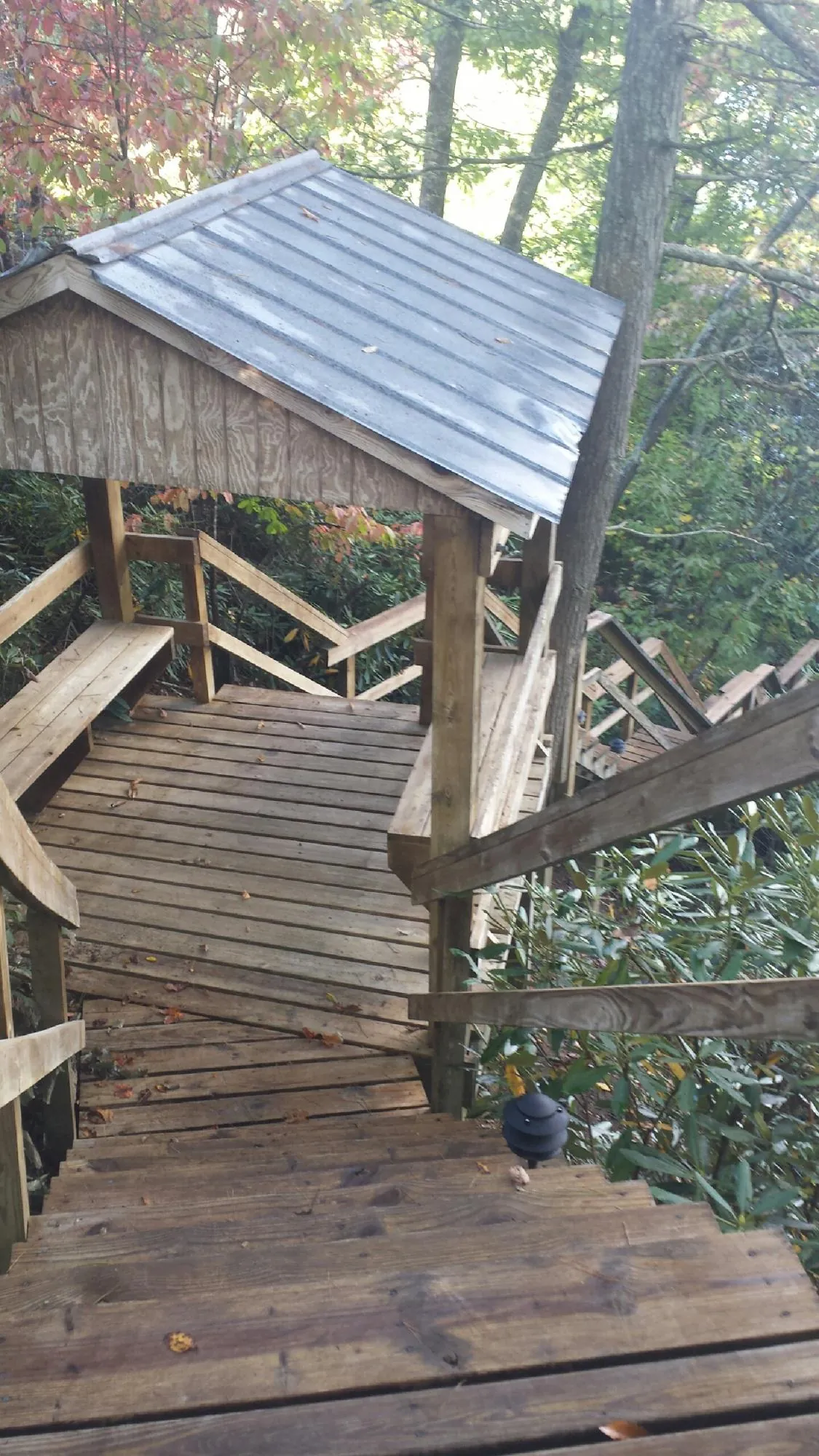 Metal roofed shelter over wooden steps on a wooded walkway — Skylight Repair & Installation work by our crew in Taneytown