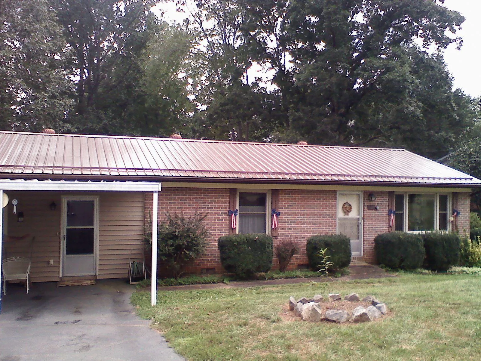 Bronze metal roof and carport on a brick ranch home — Roof Repair work by our crew in Taneytown