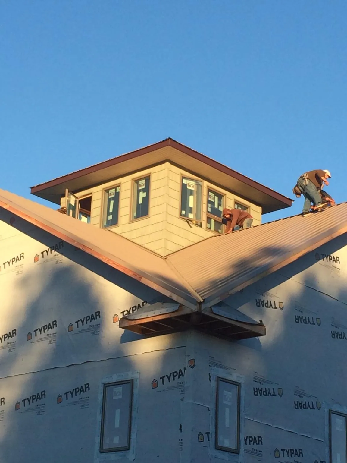 Roofers working around a rooftop cupola on a new metal roof at sunset — Roof Waterproofing in Taneytown by Roofing Brothers